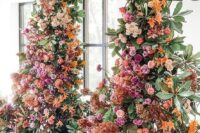 42 a luxurious colorful wedding arch decorated with greenery, blush, hot pink, orange and rust-colored blooms is wow