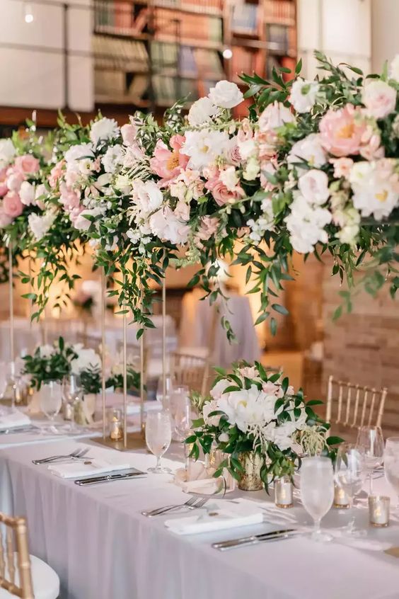 beautiful wedding table decor with neutral and blush florals incorporated with tall and usual wedding centerpieces create a blooming garden feel