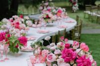 43 a lively pink wedding centerpiece of light and hot pink blooms, greenery, pink napkins and glasses is amazing