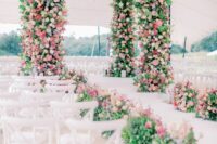 43 a massive wedding arbor covered with greenery, pink, lilac, blush and white blooms plus a matching wedding aisle