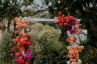 70 a bright wedding arch with a color block effect, with orange, red, hot pink, blush and white roses is wow