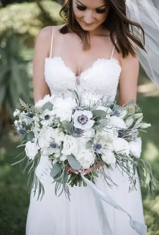 a beautiful and breezy white wedding bouquet of anemones, peonies, thistles and greenery of various kinds