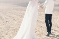 a beautiful modern bridal look with a plain off the shoulder wedding dress and a semi sheer plain capelet that accents the look a lot