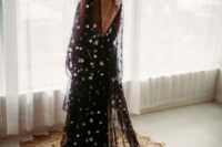 a black and gold star A-line wedding dress with illusion sleeves, an open back, a matching cape veil and a black hat