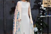 a bold modern bride wearing a minimalist white plain wedding dress with a slit and an iridescent coverup with a train