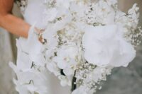 a cascading white wedding bouquet of orchids and baby’s breath is a beautiful and fresh solution for a sophisticated bride