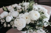 a classy all-white wedding bouquet of peony roses, peonies, some white fillers and greenery is a fresh summer idea
