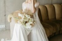 a delicate modern bridal look with a white slip maxi wedding dress, a semi sheer capelet with a train, clear shoes