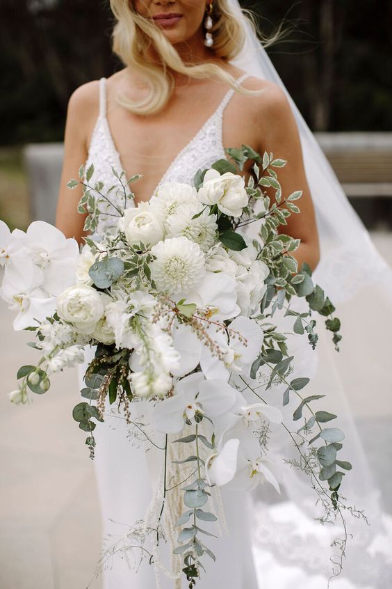 a dimensional and textural white wedding bouquet of peony roses, orchids, dahlias and greenery is a fantastic idea