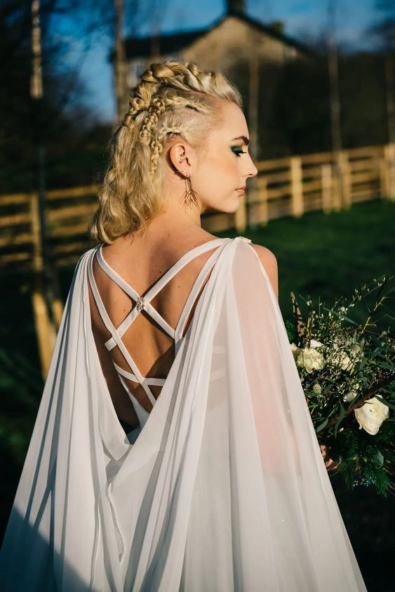 a dove grey wedding dress with a strappy back and a matching sheer cape veil are a perfect combo
