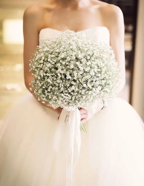 a dreamy wedding bouquet composed of only baby's breath and white ribbons is a very chic and very romantic idea