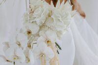 a fan white wedding bouquet of orchids, roses, dahlias, white fronds and some cascading touches is amazing