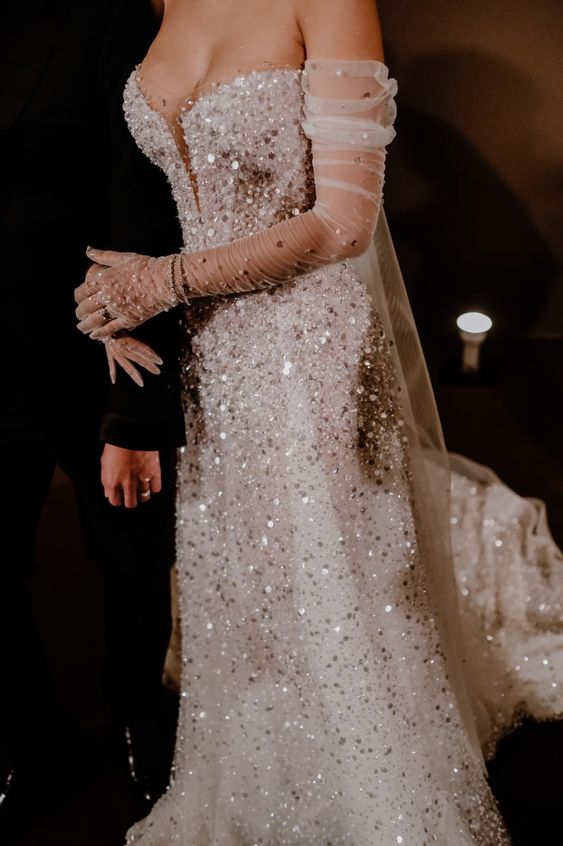 a gorgeous fully embellished strapless wedding dress paired with matching embellished mesh gloves for a more refined look