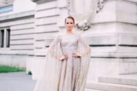a heavily embellished blush wedding gown with a matching cape looks bold, unique and modern
