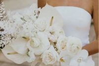a jaw-dropping white wedding bouquet that includes peony roses, orchids, roses, callas and dried white leaves