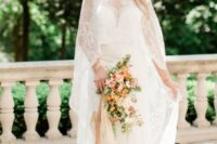 a lace wedding dress plus a matching high low long capelet with a train for a sophisticated and chic look