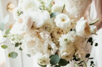a lush white wedding bouquet of peony roses, ranunculus and other blooms and greenery is a timeless idea