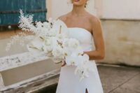 a lush white wedding bouquet with callas, orchids and some dried foliage, with a catchy shape and a cascading element is idea for a minimalist bride