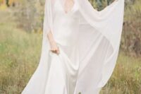 a minimalist bridal look with a slip silk maxi wedding dress with a train and a modern sheer capelet that accents the look and makes it wow