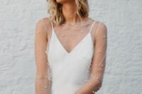 a minimalist slip wedding dress with a sheer pearl dress topper with long sleeves and a crystal crown are a lovely combo
