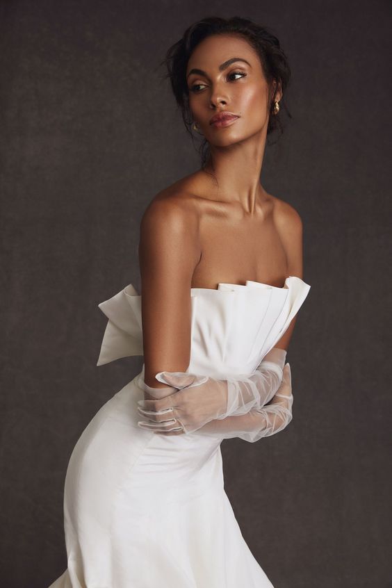 a minimalist yet romantic wedding dress paired with sheer tulle wedding gloves are a lovely and chic combo