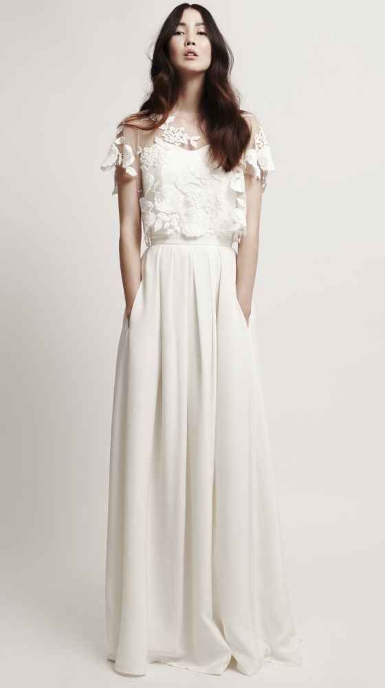 a modern plain wedding dress with a pleated skirt with pockets and a sheer lace applique dress topper with cap sleeves