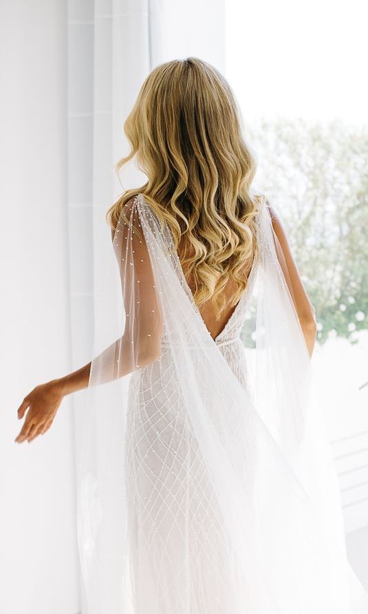 a modern wedding dress paired up with a sheer crystal cape veil are a gorgeous combo for a modern bride