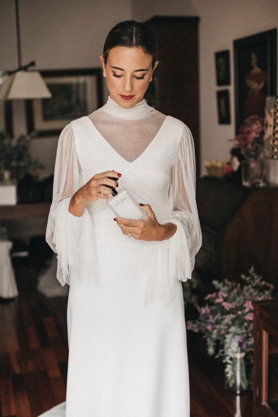 a plain wedding dress with thick straps and a V neckline plus a sheer dress topper with a turtleneck and long sleeves