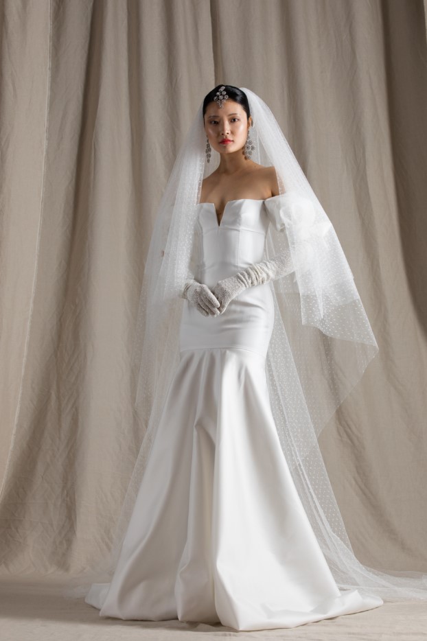 a refined strapless wedding dress with long beaded gloves, a polka dot veil and statement accessories