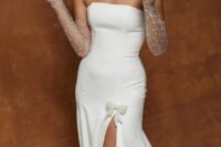 a refined strapless wedding dress with pearls and a slit accented with a bow plus sheer pearl gloves are a gorgeous combo