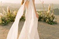 a romantic lace mermaid wedding dress with a cutout lace back and a matching sheer cape veil is wow