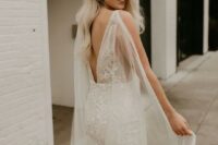 a sexy lace mermaid wedding dress with a cutout back and a sheer cape veil to make more impact and leave a longer impression