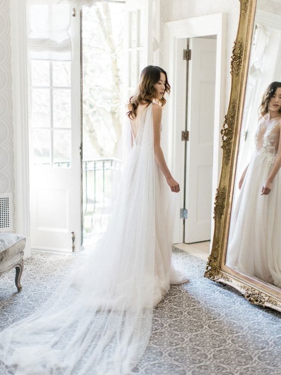 a sheer bridal cape veil with a long train is a gorgeous addition to any refined bridal look