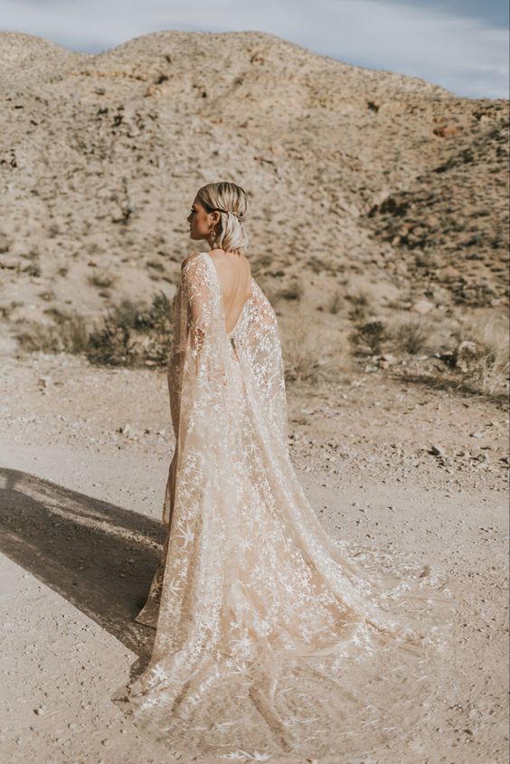 a tan embroidered star wedding dress plus a matching cape veil with a train are gorgeous for a celestial bride
