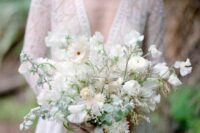 a textural and dimensional white wedding bouquet with some greenery and white ribbons is a fresh and cool idea