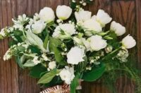 a white wedding bouquet of smaller and larger blooms and much greneery for a textural touch