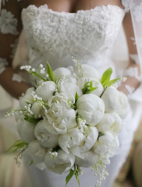 an all-white wedding bouquet of peonies and lily of the valley is a beautiful idea for an elegant bride