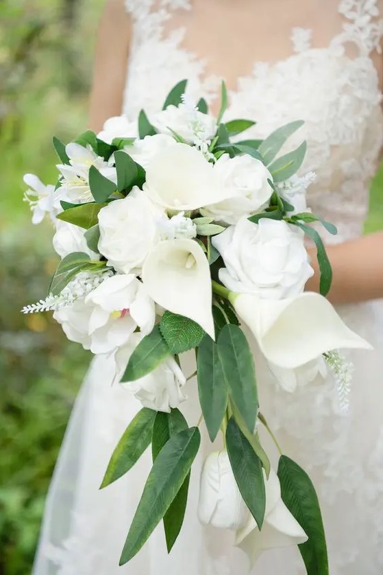 an exquisite cascading wedding bouquet of calla lilies, roses and some white fillers plus greenery is amazing for spring