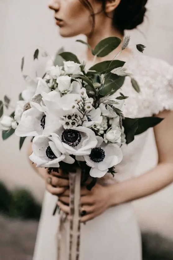 an eye-catchy wedding bouquet composed of waxflower and white anemones plus some grasses and foliage and ribbons to accessorize it