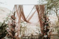 02 a beautiful and breezy wedding backdrop with blush drapes, pink and white blooms and branches on both sides of the arch