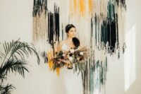03 a boho wedding backdrop of white, yellow and dark green and black fringe plus greenery around is a lovely idea to try