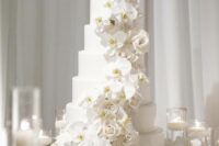 03 a chic and refined white wedding cake with white orchid and rose swirls is a very stylish idea for a formal wedding