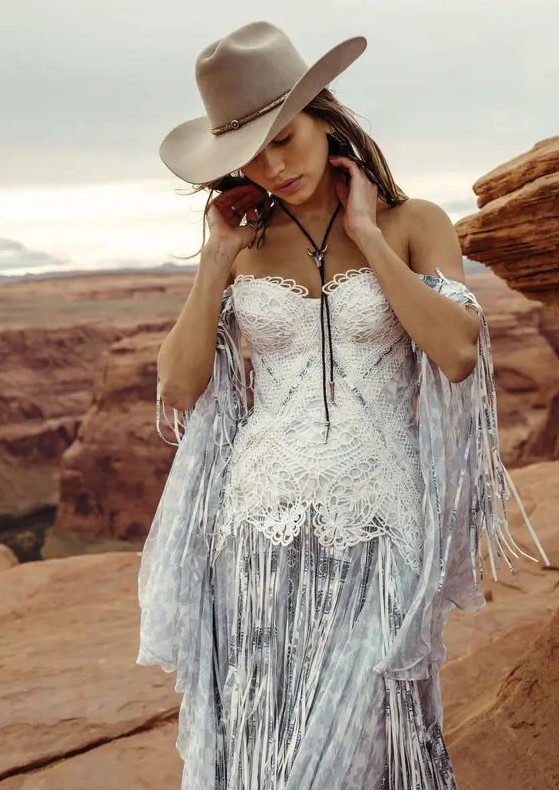 a blue printed corset off the shoulder wedding dress with white lace on the bodice and long fringe plus a hat for a boho feel