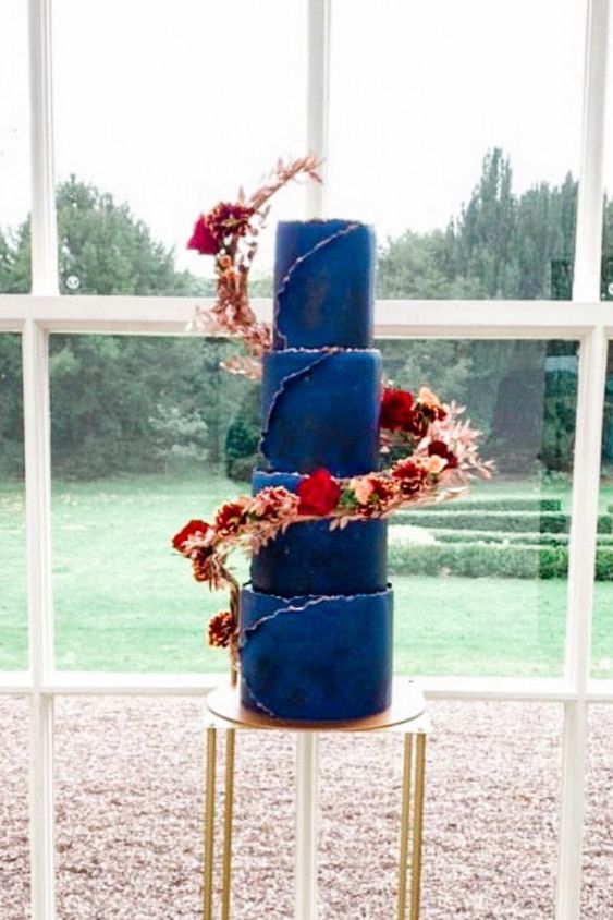 a navy wedding cake with a raw edge and pink and burgundy bloom swirls around it is a very chic idea
