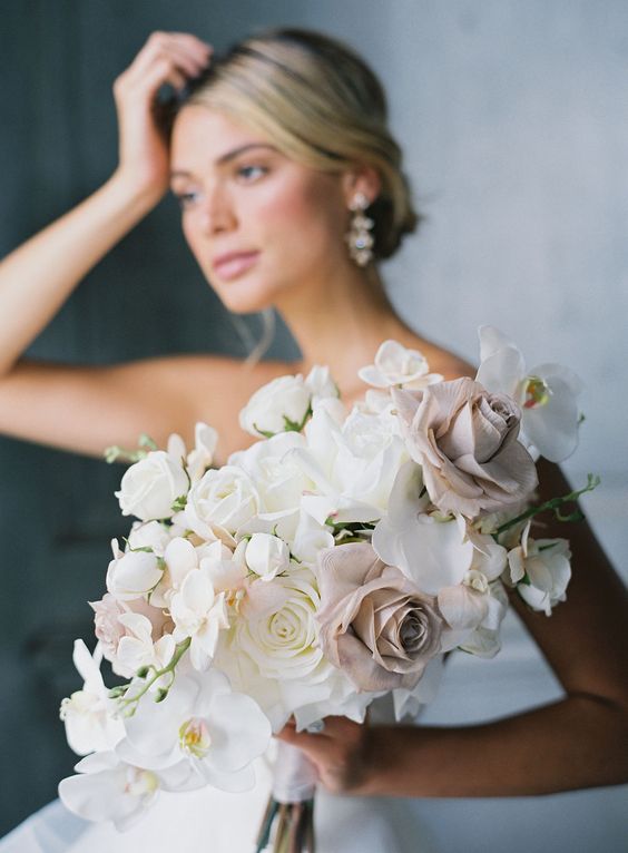 a beautiful modern wedding bouquet of mauve and white roses, white rochids is a lovely and chic idea for a modern wedding