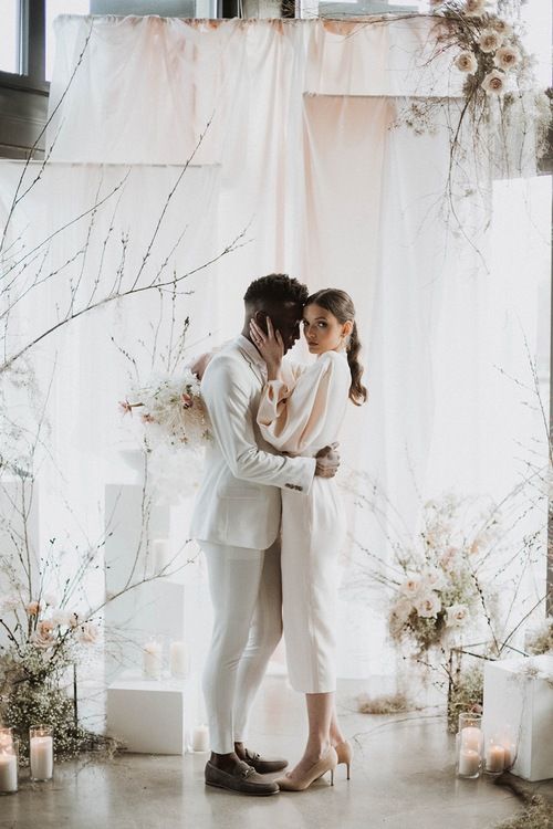 a beautiful neutral wedding backdrop of white and peachyd rapes, fresh blush blooms and branches, pillar candles is a chic idea