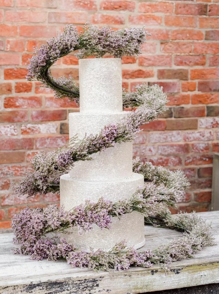 a neutral textural wedding cake with a fantastic blooming swirl around it to make its look ultimate and sophisticated