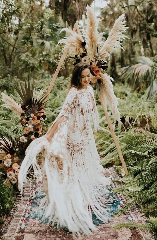 a boho lace sheath wedding gown all covered with long fringe looks very breezy and wild, perfect for a western wedding