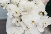 07 a cascading white wedding bouquet composed of ranunculus and orchids looks very sophisticated