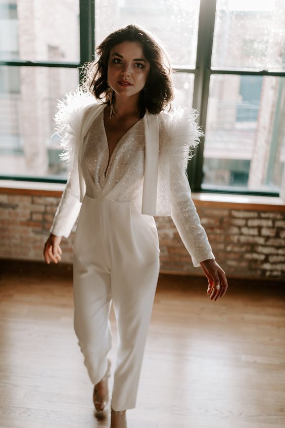a fantastic bridal look with a jumpsuit with an embellished draped bodice and plain pants, a matching embellished and feathered blazer